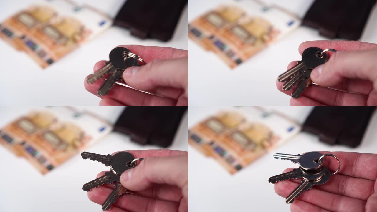 闪亮的新公寓钥匙在一个男人的手中，欧元钞票和白色背景上的钱包