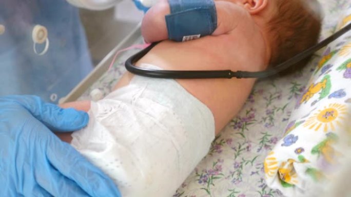 产妇之家概念。拯救婴儿的生命。在医生监督下的孵化器中的早产儿。护士手戴着蓝色手套拿着奶瓶的特写镜头。