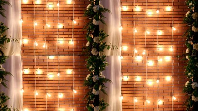 砖墙附近的灯泡花环。庆祝用灯装饰。