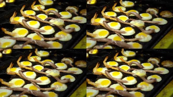 4k街头小贩准备鱿鱼触角和虾的煎鹌鹑蛋