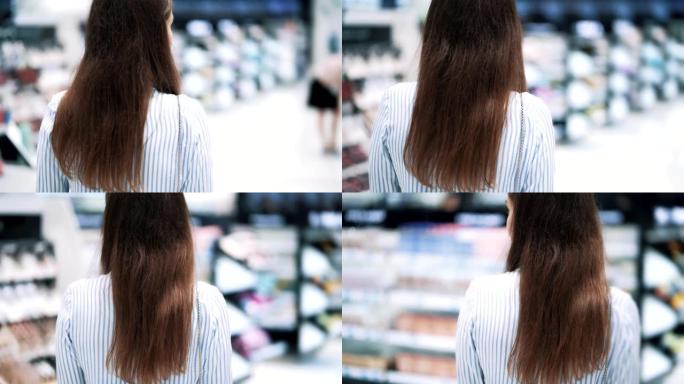 背面视图，女人在化妆品店的货架上走，慢动作