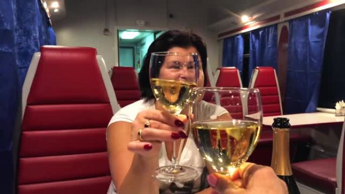 两名妇女坐在火车餐厅的汽车上喝香槟