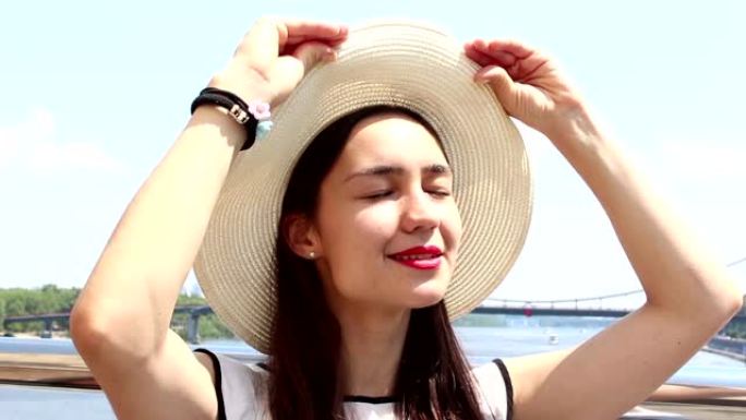 一个戴着白帽子的美丽年轻女孩的特写肖像。戴着白帽子的年轻迷人女孩，将目光投向天空，斜视着太阳。