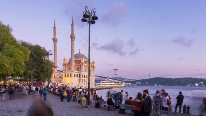 时间流逝: 白天到晚上，游客行人在土耳其伊斯坦布尔市的奥塔科伊清真寺度假时拥挤
