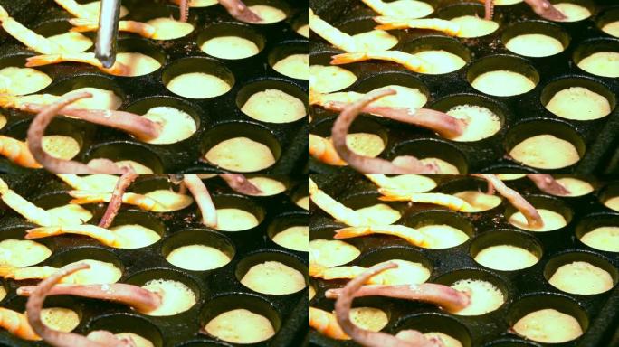 小贩用鱿鱼触角烹饪煎鹌鹑蛋的慢动作