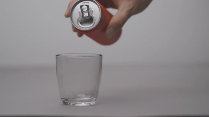 男人打开红色汽水罐，在玻璃杯里装满糖。软饮料和苏打水中的糖。选择性聚焦镜头