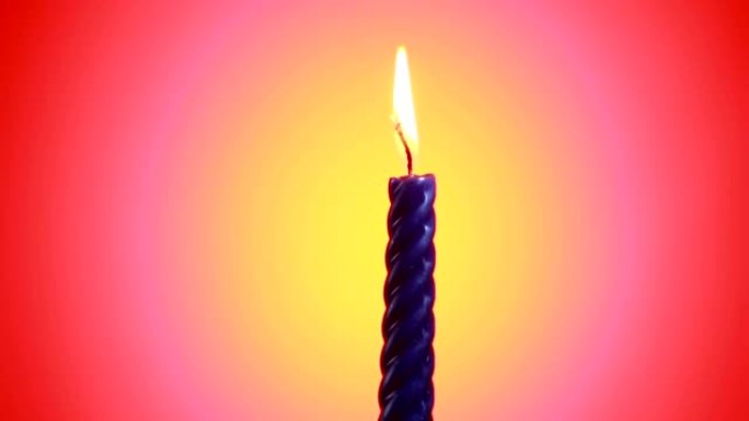 燃烧和旋转的蓝色蜡烛与燃烧的火焰