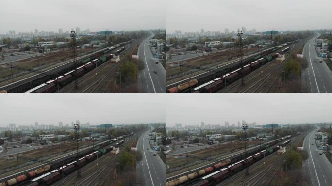 长货运列车通过城市的工业火车站和火车轨道在货车和油箱中运输货物