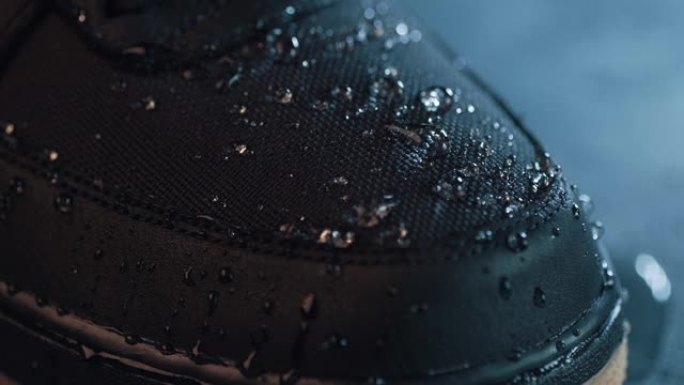 鞋子表面防水膜织物上的水滴，慢动作宏观拍摄。积极生活方式的服装和鞋类防水新技术