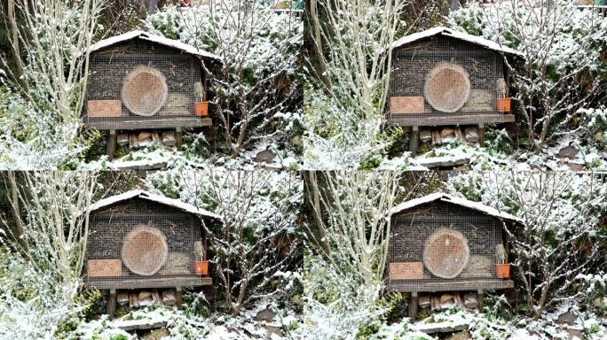 冬季野生蜂虫酒店。花园里下雪。