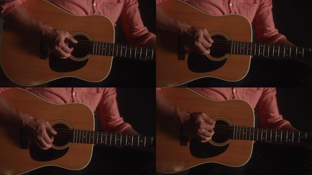 音乐家在昏暗的空间中用手指拨动原声吉他的特写镜头