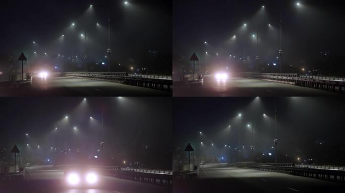 汽车晚上在潮湿的雾气路上行驶。危险的夜间驾驶。高速公路上的灯亮着