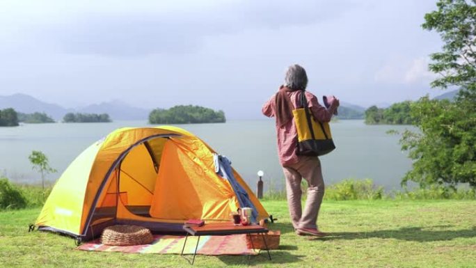 独自一人的老人醒来，从帐篷里看到湖的自然景象