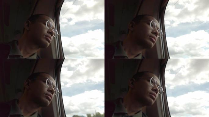 4k散焦悲伤的年轻人透过火车窗户看。