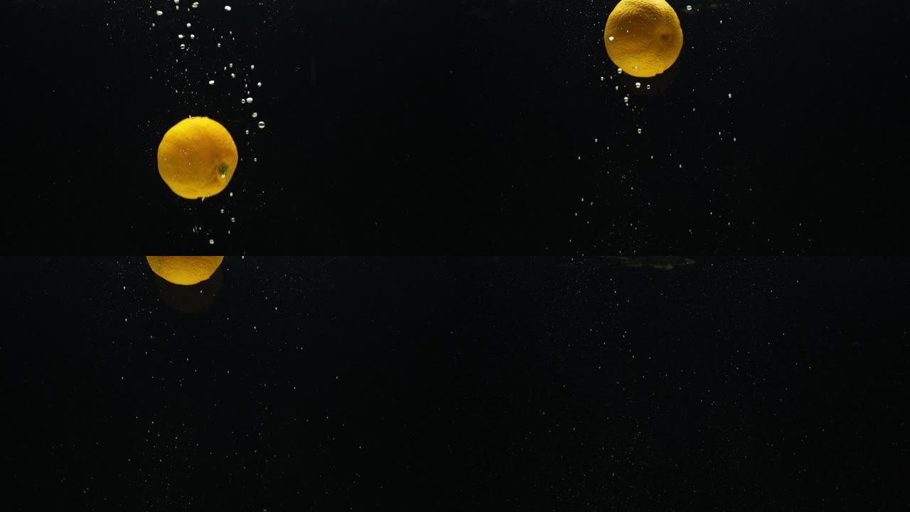 慢动作视频，橘子，普通话在黑色背景上掉入水中