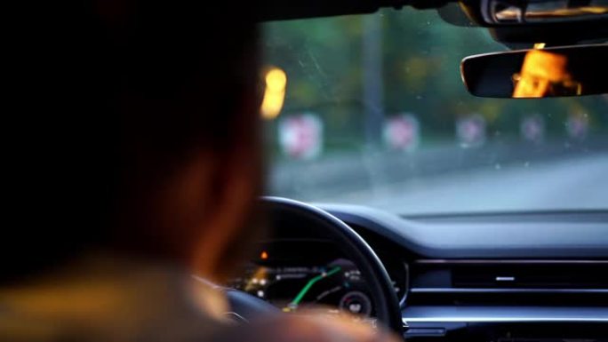 晚上在汽车转向过程中，男人的方向盘后座的特写镜头遵循驾驶规则关心安全