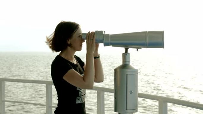 深色头发的女人透过地中海的旅游双筒望远镜看。4K