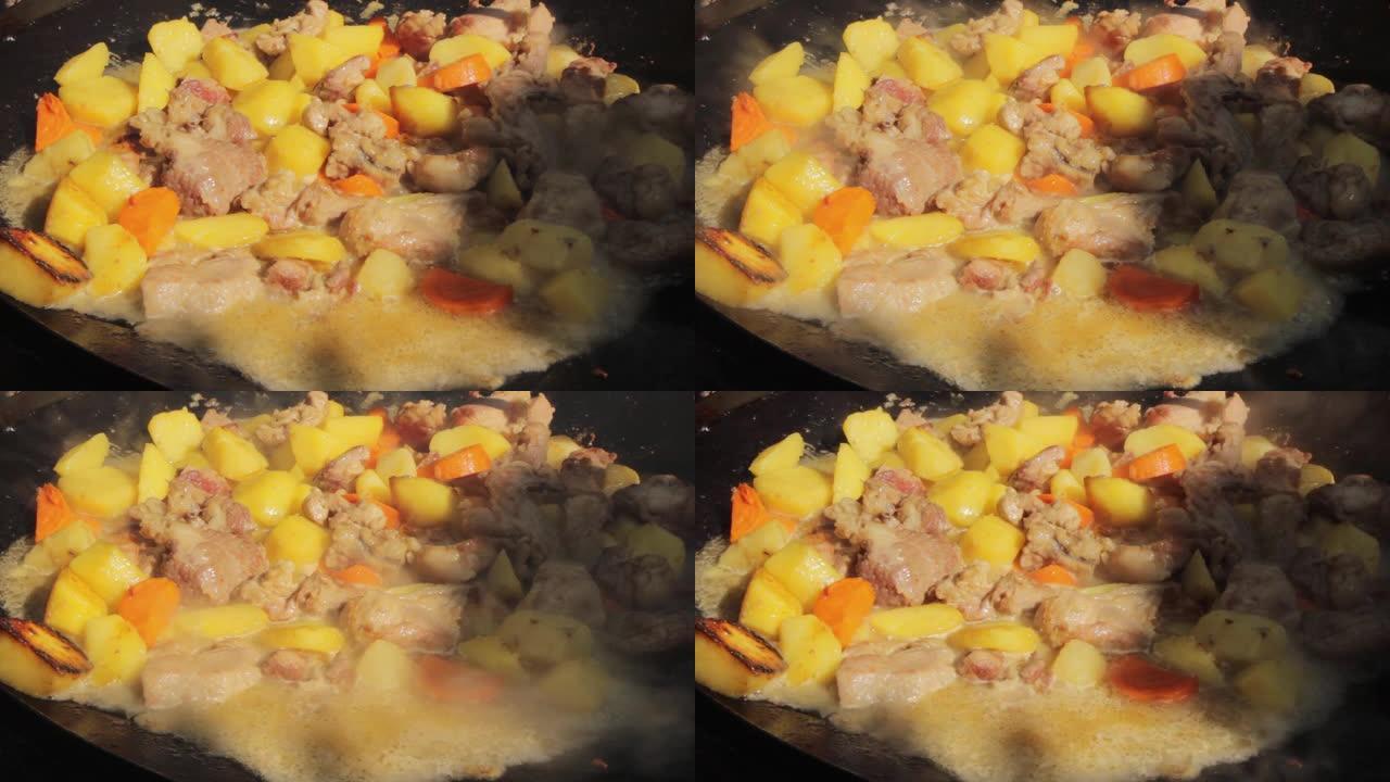 在夏天阳光明媚的日子，在一个巨大的煎锅里用篝火炒美味的土豆和肉，特写