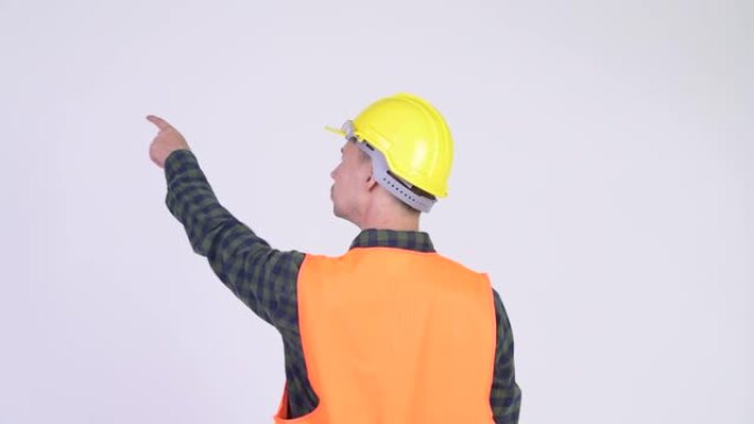 用安全帽指指点点的男子建筑工人的后视图