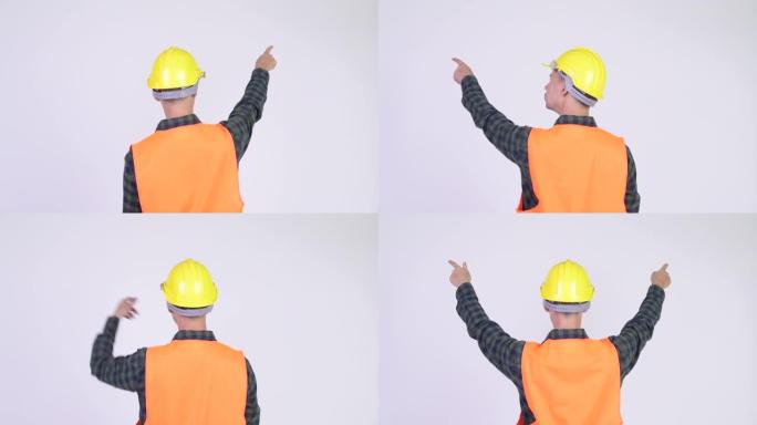 用安全帽指指点点的男子建筑工人的后视图