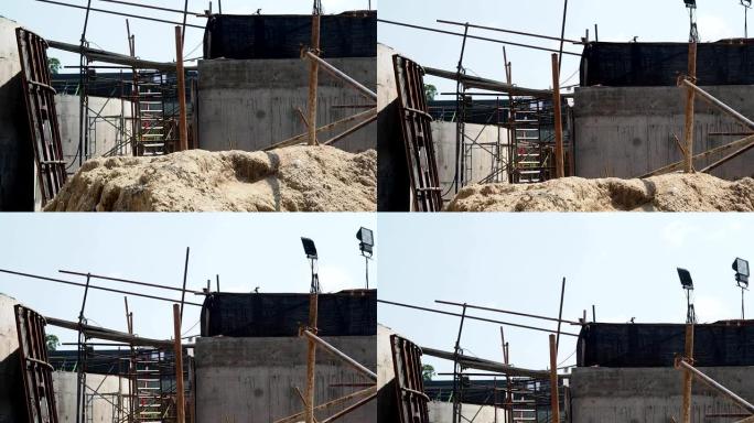 用沙堆和脚手架结构向上倾斜建筑工地。