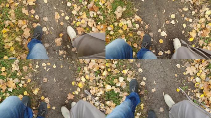 情侣们走在秋天的公园里，男女双脚走在小路上。