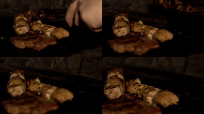 在slowmo的餐厅里，用烤炉在烧烤炉上烤的一盘串肉和肉块的特写镜头。在烧烤架上烹饪传统的民族菜Sh