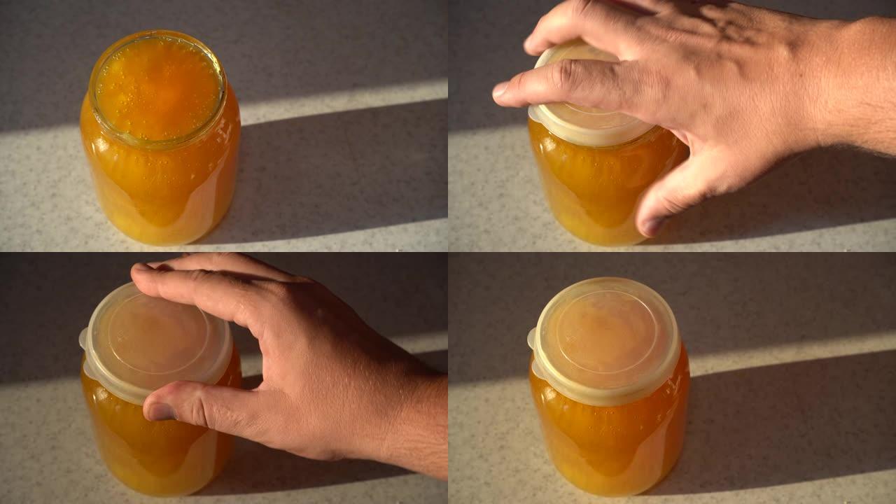 新鲜的蜂蜜正被倒入罐子里。特写。