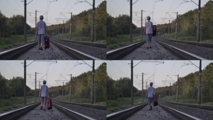 带旅行袋的有趣男孩在户外乘火车