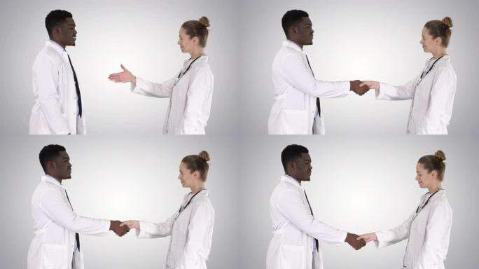 两名年轻医生在渐变背景上握手