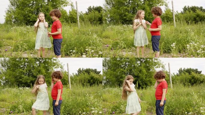 暑假时，卷曲的男孩和女孩在绿色的田野上散步时看花。哥哥在夏天的草地上给姐姐田花。孩子们在开花的草坪上
