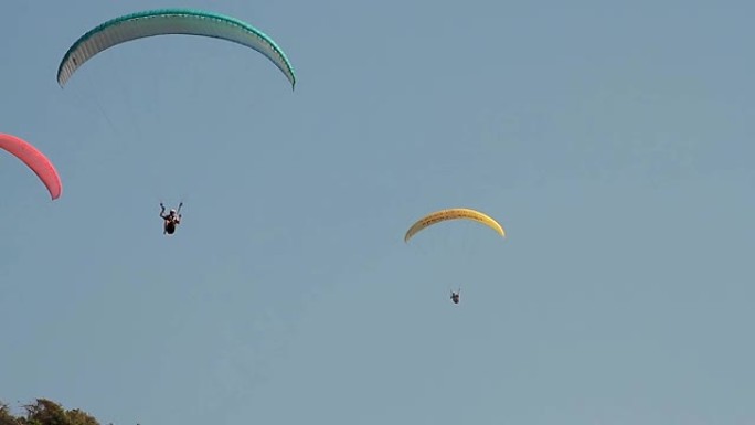 在湛蓝的天空中滑翔伞在山上