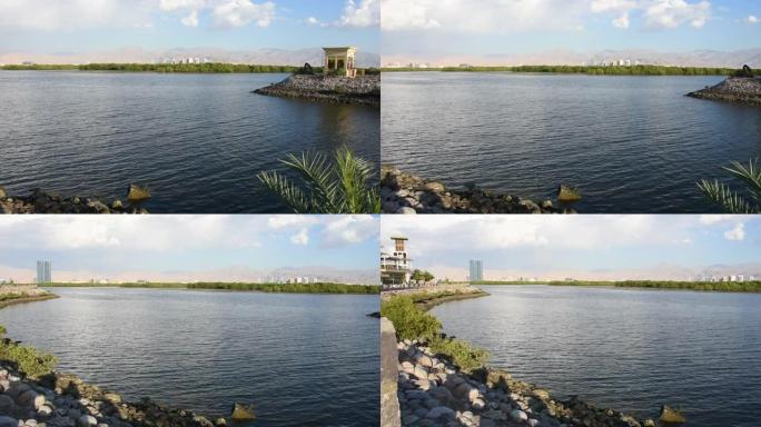 下午晚些时候，阿拉伯联合酋长国拉斯海玛市的全景在滨海大道上，从桥上看到清晰清晰的蓝色山景。