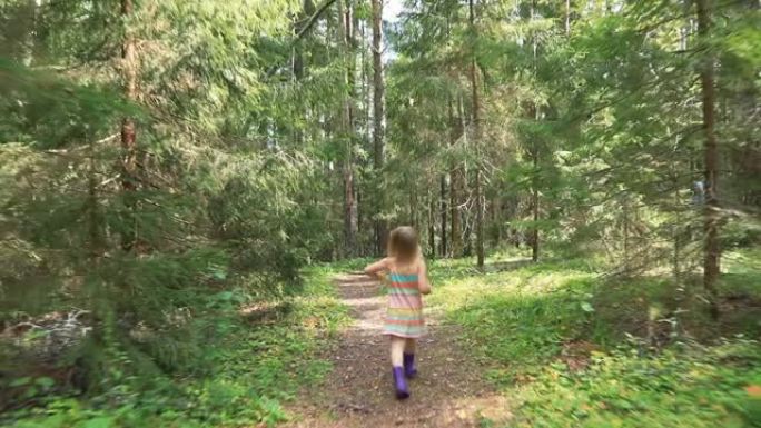 小女孩在夏天的森林里走在人行道上