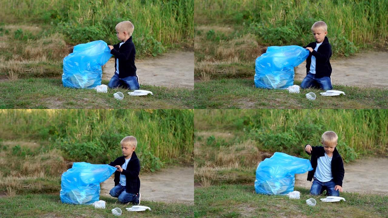 一个小男孩在公园的河边或湖边的海滩上收集垃圾。