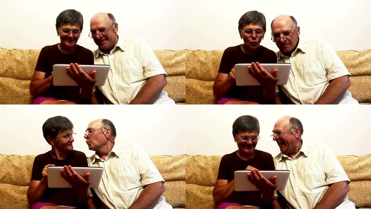 一对老年夫妇正坐在家里的沙发上，在平板电脑上看照片，面带微笑，积极交谈。