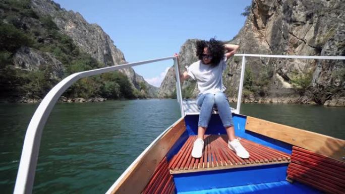美丽的女人在马其顿斯科普里的马特卡湖上的一艘传统小船上享受着她的旅行