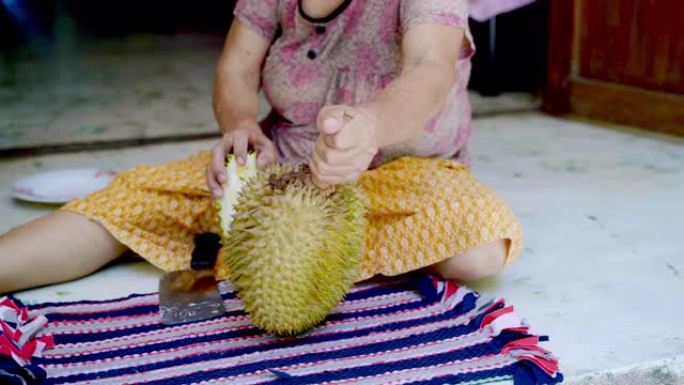 女人试图在泰国剥榴莲果王。