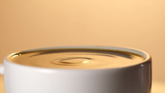 浓缩咖啡以慢动作从咖啡机中放入装满的杯子中