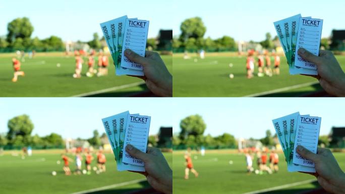 在一场体育场足球比赛的背景下，一名男子拿着庄家的彩票和欧元钞票