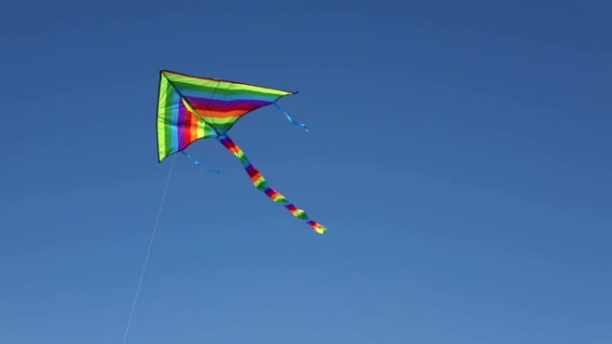 彩虹风筝在万里无云的蓝天下高高飘扬。