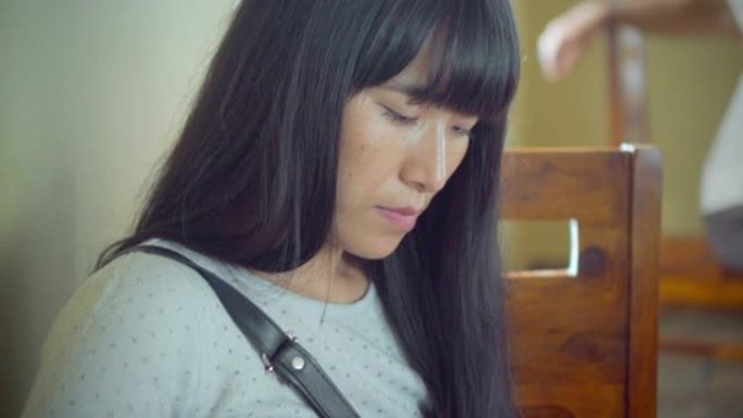 亚洲宁静的年轻女子在餐厅使用智能手机。