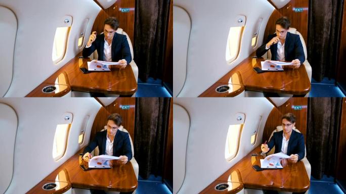 忙碌的商人在乘坐私人喷气式飞机飞行时处理文件。商务舱。