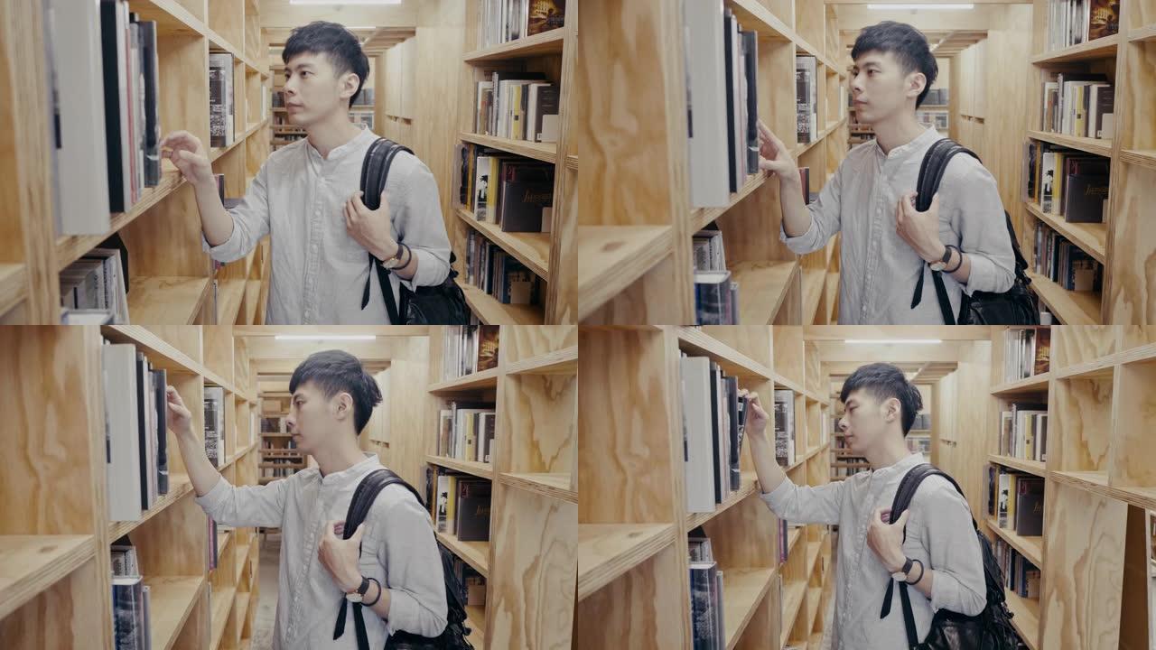 年轻的亚洲男大学生在图书馆寻找书 (慢动作)
