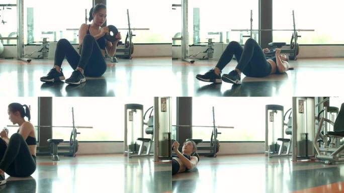 年轻的亚洲迷人的运动女性在健身馆用杠铃举重板做十字交叉或扭动侧嘎吱声。运动锻炼和锻炼。健康的生活方式