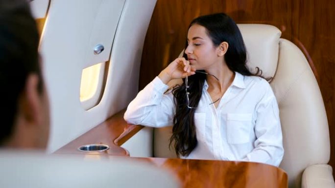 美丽成功的商界女性乘坐私人飞机旅行。出差。穿着经典。百万富翁女孩坐飞机坐商务舱。