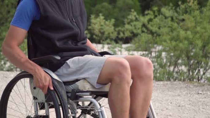 坐在轮椅上的残疾年轻学生男子的慢动作特写