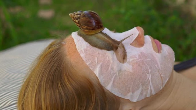 年轻女子用蜗牛粘液做口罩。蜗牛在面罩上爬行