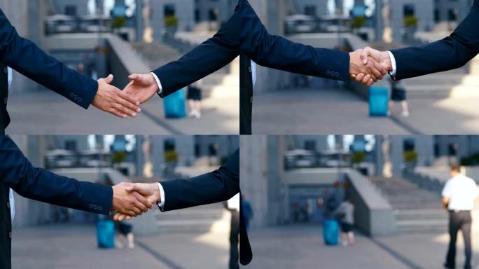 商务中心背景上的两个人握手。成功的交易或问候概念。两个商业伙伴见面时握手