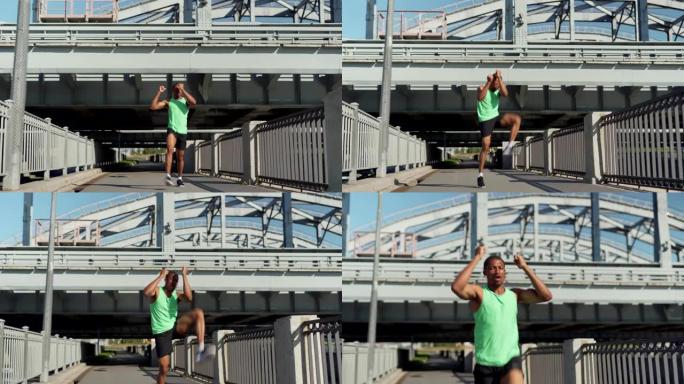 在城市大桥上跑步训练期间，坚定的年轻非洲运动员练习膝盖到肘部热身运动的全长宽镜头